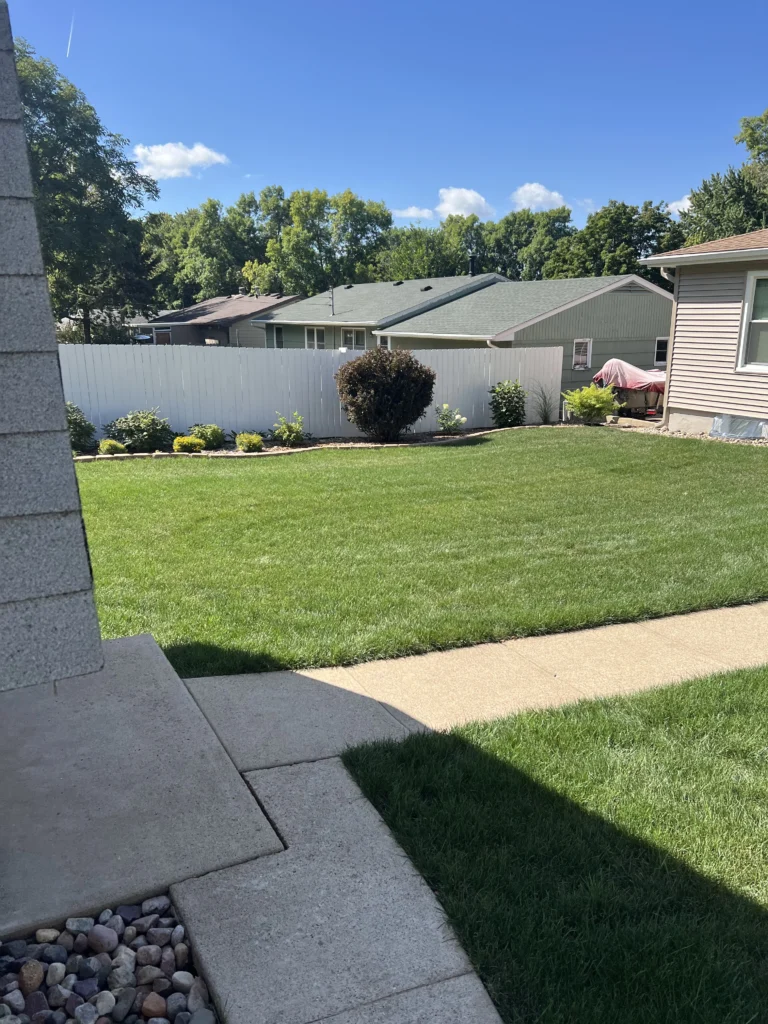 Well-maintained green lawn with neat edging and landscaping, showcasing an inviting outdoor space in Sioux Falls, SD, reflecting the quality of services offered by Next Level Outdoor Services.