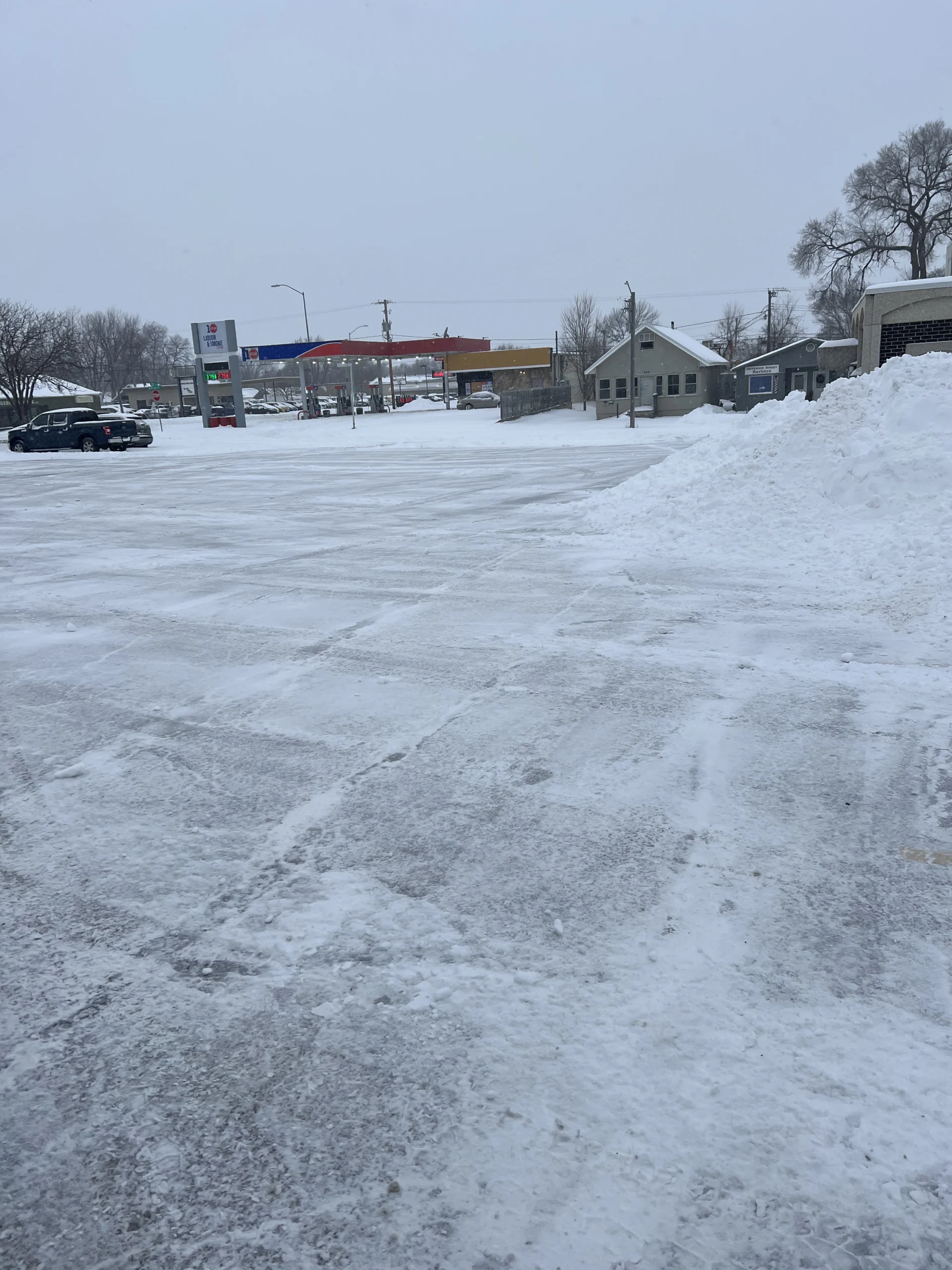 Snow-covered commercial parking lot with cleared pathways, showcasing effective snow removal services by Next Level Outdoor Services in Sioux Falls, SD.