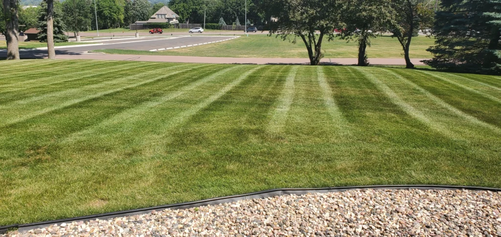 Lush, well-manicured lawn with distinct mowing stripes, showcasing professional lawn care services in Sioux Falls, SD.